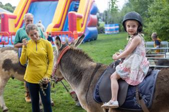 Little girl enjoys a donkey ride with Bath City Farm donkey.