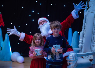 children pose with Santa and their gifts