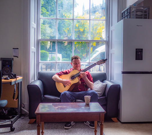 Eddy and his guitar sitting on the sofa