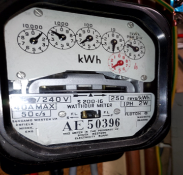Close-up of an analogue electricity meter with five circular dials displaying electricity consumption in kilowatt-hours (kWh).