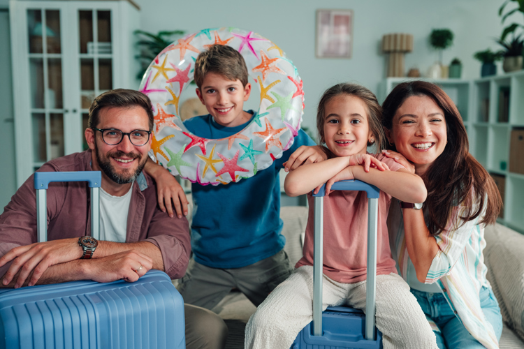 A family pose with suitcases and a rubber ring