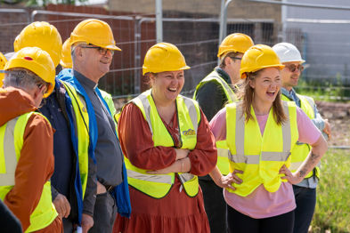 People in hard hi vis and hard hats laughing