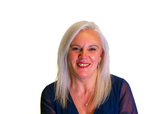 Michelle Sage has white blonde hair, a big smile and red lipstick.
